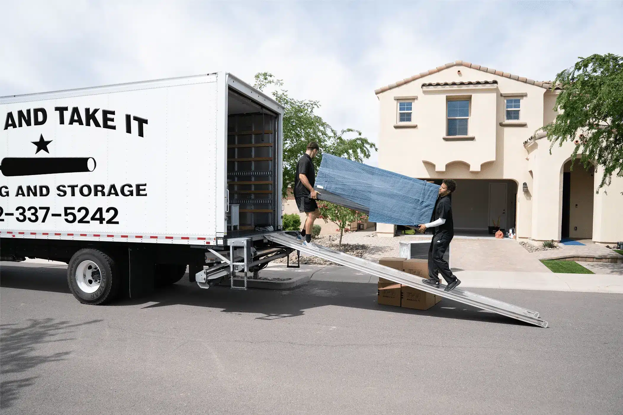 two members of Come and Take it Moving loading boxes in a truck